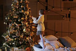 Sweater Prints: Side view of a child decorating a Christmas tree
