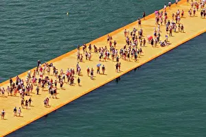 Installation Prints: View from above of crowds of people on the Floating Piers Project for Lake Iseo which is an artwork by Christo