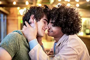 Cafe Prints: Side view of excited ethnic men embracing each other with closed eyes on table
