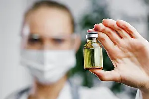 Doctors Prints: Front view female researcher with vaccine bottle