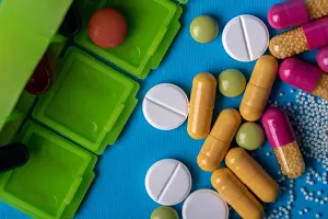 Drug Prints: Top view with a green organizer and capsules and multicolored pills