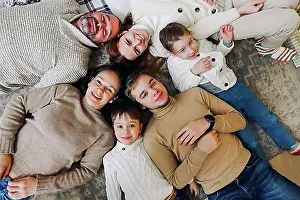 Grandma Prints: Top view of happy big multi-generation family lying in circle on floor and smiling at camera