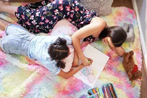 Disability Prints: View from above mother and daughter drawing circles in notebook