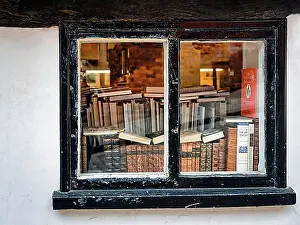 Looking Through Prints: View through an old window on stacks of books