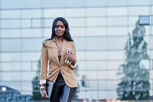 Suit Prints: front view portrait of black woman wearing a brown suit talking on the phone