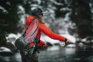Recreation Prints: Side view of woman fly fishing during vacation in winter