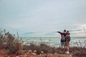Associate Prints: Back view of young gay couple looking at the sea