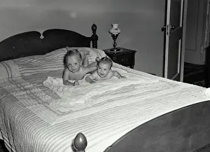 Vintage Photograph. Two babies laying on their stomach on a bed