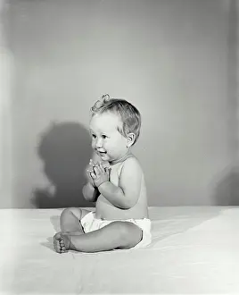 Soft Focus Prints: Vintage Photograph. Baby clapping hands and looking to the left of frame