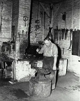 Work Tool Prints: Vintage Photograph. Blacksmith pounding out horseshoe on anvil