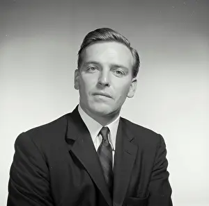 Release Prints: Vintage Photograph. With a blank stare a man sits for a studio portrait