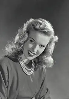 Wavy Prints: Vintage photograph. Blonde woman with wavy hair wearing blouse and pearl necklace smiling