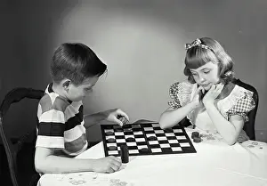 Models Prints: Vintage photograph. Children at table playing checkers