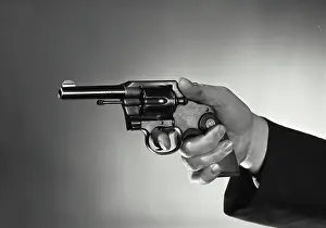 Aiming Prints: Vintage Photograph. Close-up of a person's hand holding a revolver