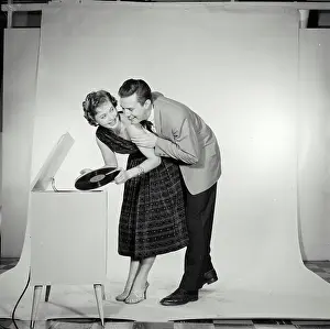 Record Prints: Vintage Photograph. Couple playfully switches the record on the jukebox next to them while in studio
