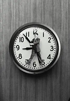 Business Suit Prints: Vintage Photograph. Cutout of man wearing suit walking placed on clock face, Frame 1