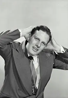 Bill Prints: Vintage photograph. Dark haired man with frustrated expression holding up hands to head