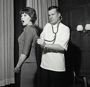 Examination Prints: Vintage Photograph. A doctor checking patient's breathing while they stand in office