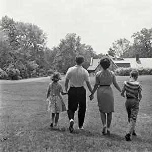 Greenery Prints: Vintage Photograph. Family of four walking in field away from camera