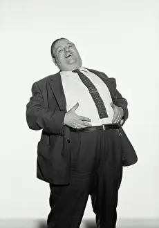 Heavy Prints: Vintage Photograph. Fat man wearing suit and tie laughing with hands on stomach