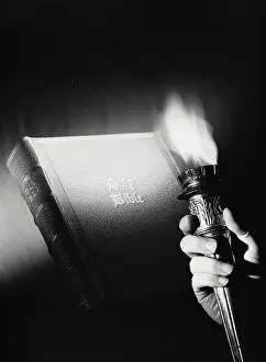 Burning Prints: Vintage Photograph. Hand holding torch with flame in front of Holy Bible, Frame 2