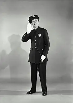 First Responders Prints: Vintage photograph. Full length portrait of policeman with whistle with hand raised looking concerned
