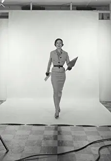 Skirt Prints: Vintage Photograph. Full length view of woman wearing light grey skirt and jacket and hat on white studio background