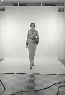 Skirt Prints: Vintage Photograph. Full length view of woman wearing light grey skirt and jacket and hat on white studio background