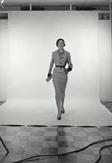 Skirt Prints: Vintage Photograph. Full length view of woman wearing light grey skirt and jacket and hat on white studio background