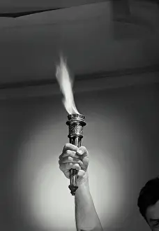 Spotlight Prints: Vintage Photograph. Male hand holding up torch with flame above head