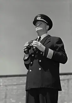 Vintage Photograph. Man in captains uniform standing with binoculars