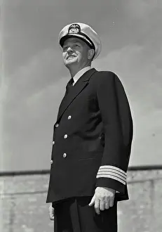 Sailor Prints: Vintage Photograph. Man in captains uniform standing and looking off camera and smiling