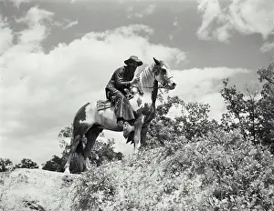 Covering Prints: Vintage Photograph. Man in chaps and bandana riding on horses back. Frame 2