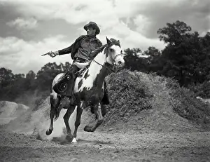 Wild West Prints: Vintage Photograph. Man in chaps riding on horses back shooting gun. Frame 2