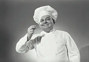 Chef Prints: Vintage Photograph. Man in chefs uniform tasting an imaginary spoon
