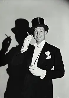 Smoking Prints: Vintage Photograph. Man in top hat and tuxedo holding cigarette up with shadow behind him