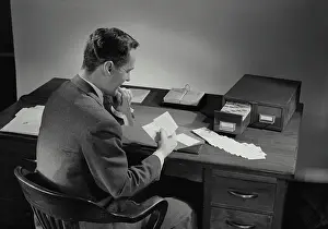 Bill Prints: Vintage Photograph. Man in suit sitting at desk covered in papers. Frame 4