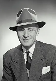 Vintage photograph. Man in suit and tie wearing hat and smiling at camera