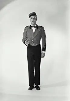 Builder Prints: Vintage Photograph. Man wearing bellman uniform standing on white background