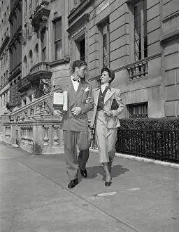 George Prints: Vintage photograph. Man and wife walking down street with arms locked