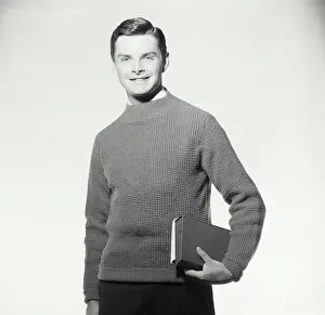 Sweater Prints: Vintage Photograph. A midshot of a young man wearing a sweater carrying books
