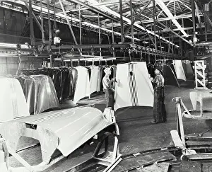 Paint Prints: Vintage photograph. Painted hoods are placed on a conveyer in the paint shop and travel to final assembly plant