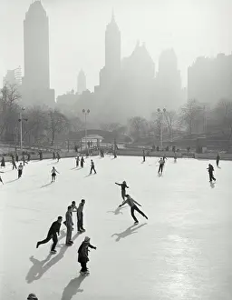 Skate Prints: Vintage photograph. People skating at Wollman Memorial Ice Rink in Central Park with hazy buildings in background