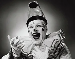 Circus Prints: Vintage photograph. Portrait of clown in silly hat with excited expression