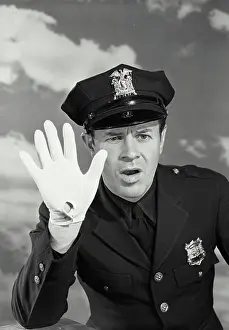 Gloves Prints: Vintage photograph. Portrait of a policeman holding up gloved hand