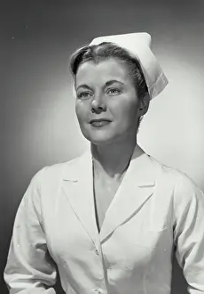 Joan Prints: Vintage photograph. Portrait of woman in nurse uniform looking off camera
