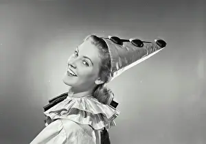 One Young Woman Only Prints: Vintage photograph. Portrait of a young woman in clown suit looking over shoulder and smiling