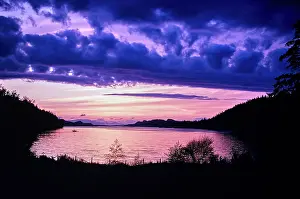 Canoe Prints: Vintage Photograph. Serene sunset over tranquil lake with vibrant purple clouds