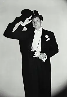 Society Prints: Vintage Photograph. Smiling man wearing tuxedo putting on top hat
