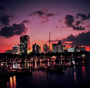 Moody Prints: Vintage Photograph. Stunning waterfront cityscape during a vibrant sunset reflected on the harbor